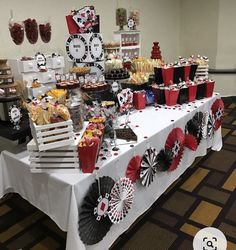 a table topped with lots of desserts and candy bar items on top of a white table cloth