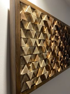 a wooden wall hanging on the side of a white wall