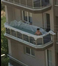 an apartment building with two balconies covered in tarps