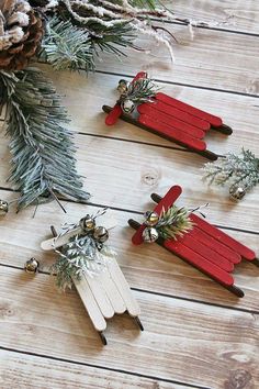 two red and white popsicle christmas decorations on wooden planks with pine branches in the background