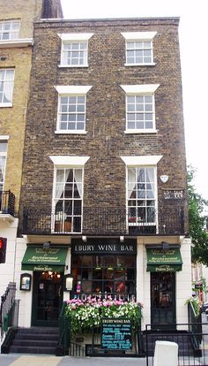 an old brick building with many windows on the front and side of it's facade