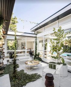 an outdoor living area with white furniture and plants