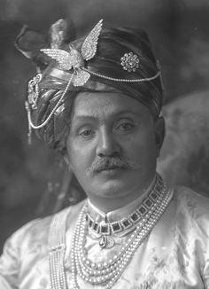 an old black and white photo of a woman in costume with pearls on her head