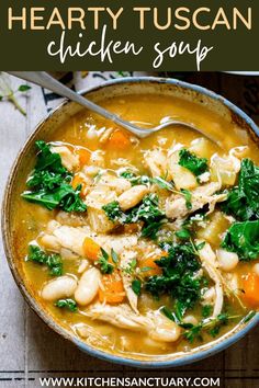 two bowls of chicken and vegetable soup on a wooden table with bread slices in the background