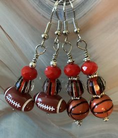 red and black beaded sport earrings. one pair of football earrings and one pair of basketball earrings. football and basketball are plastic.  other beads are glass.   silver ear wires. Diy Sports Earrings, Sport Earrings, Basketball Earrings, Sports Earrings, Football Earrings, Wisconsin Badgers, Football And Basketball, Black Beads, Red And Black