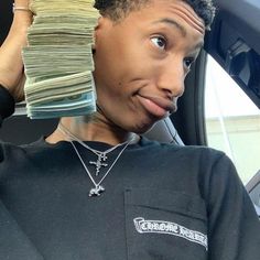 a person with a stack of money on their head in the back seat of a car