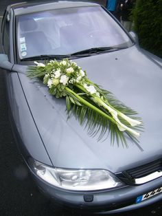 a bouquet of flowers is placed on the hood of a car parked in a parking lot