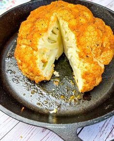 a cooked cauliflower in a cast iron skillet