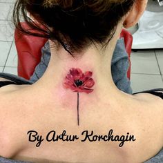 the back of a woman's neck with a red flower on it