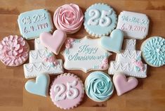 decorated cookies are arranged in the shape of hearts and flowers on a wooden table top