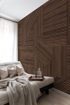 a white couch sitting in front of a window next to a wooden paneled wall