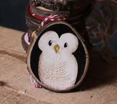 an owl is sitting on top of a piece of wood with a ribbon around its neck