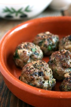 a bowl filled with meatballs on top of a wooden table