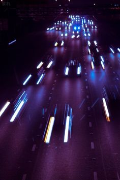 many cars are driving down the highway at night time, with bright lights on them