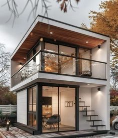 a small white house with stairs leading to the upper floor and second story balcony area