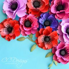 paper flowers are arranged on a blue background