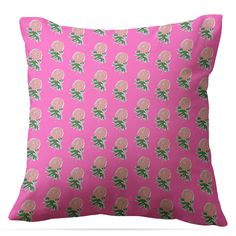 a pink pillow with green leaves and flowers on the front, against a white background