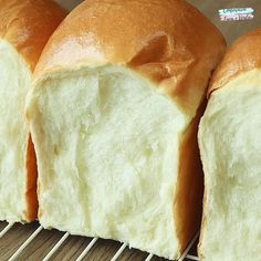 three loaves of bread sitting on top of a cooling rack