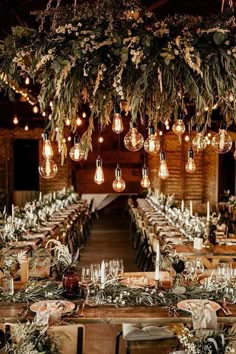 the tables are set with candles, greenery and hanging lights for an elegant wedding reception