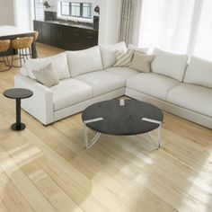 a living room with white furniture and wood floors