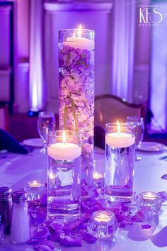 the centerpieces are filled with flowers and lit candles