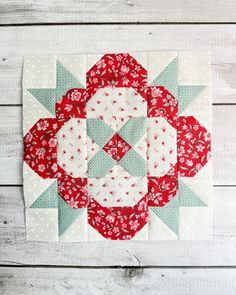 a red and white patchwork quilt on a wooden background with text overlay that says,