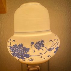 a blue and white vase sitting on top of a table next to a light fixture