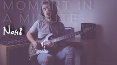 a man sitting in front of a desk with an electric guitar