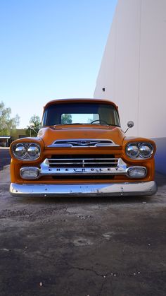 an orange truck parked next to a white building