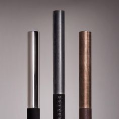 three different types of metal tubes are shown in this image, one is brown and the other is silver