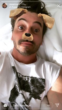 a man laying in bed with a fake teddy bear on his head and eyes wide open