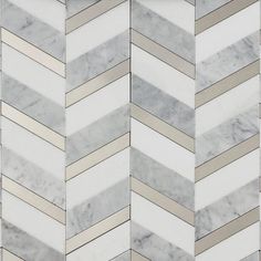 a white marble herringbone pattern with gold and silver lines on it's sides