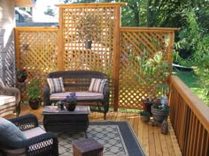 a wooden deck with wicker furniture and potted plants