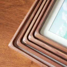 a stack of wooden frames sitting on top of a wooden table next to each other