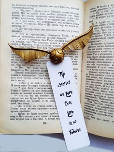 a bookmark with an image of a golden bird on it and the words, if stories we love don't live in us forever