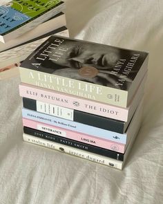 a stack of books sitting on top of a bed