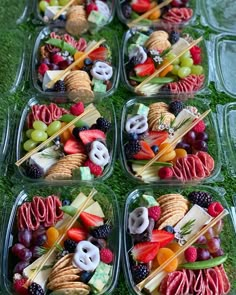 four plastic containers filled with different types of food on top of green carpeted ground