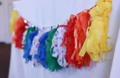 colorful streamers are hanging from the side of a white table cloth draped over it