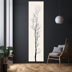 a black and white wall with a tree in the corner, next to a chair