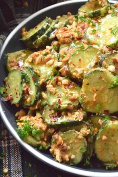 a plate filled with cucumbers and other vegetables on top of a table cloth