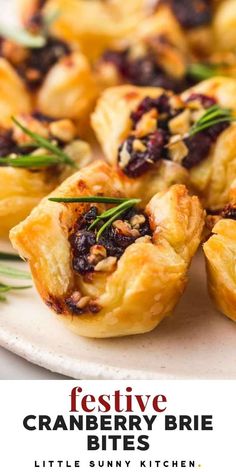 cranberry brie bites on a white plate with rosemary garnishes