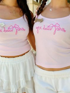 two girls wearing pink shirts and white shorts