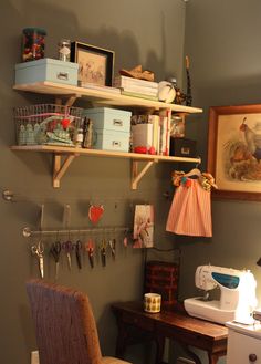 a sewing machine sitting on top of a wooden table next to a shelf filled with craft supplies