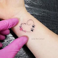 a person with a small tattoo on their left arm and paw prints on the wrist