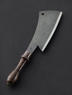 a large knife with a wooden handle on a black surface