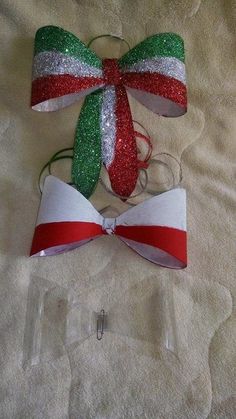 two bows with different colors and designs are laying on a white blanket next to each other