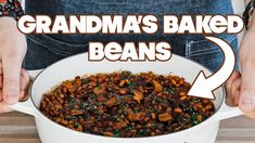 someone is holding a bowl full of beans and meat in front of the words grandma's baked beans