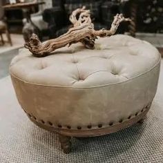 a round ottoman sitting on top of a rug