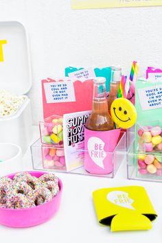 a table topped with plastic containers filled with donuts and other items on top of it