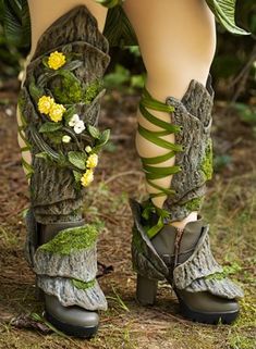 the legs and ankles of a woman wearing boots with flowers on them are covered in moss